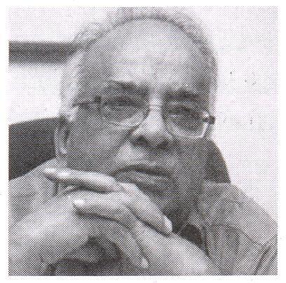 A black and white photo of a man sitting at a desk.